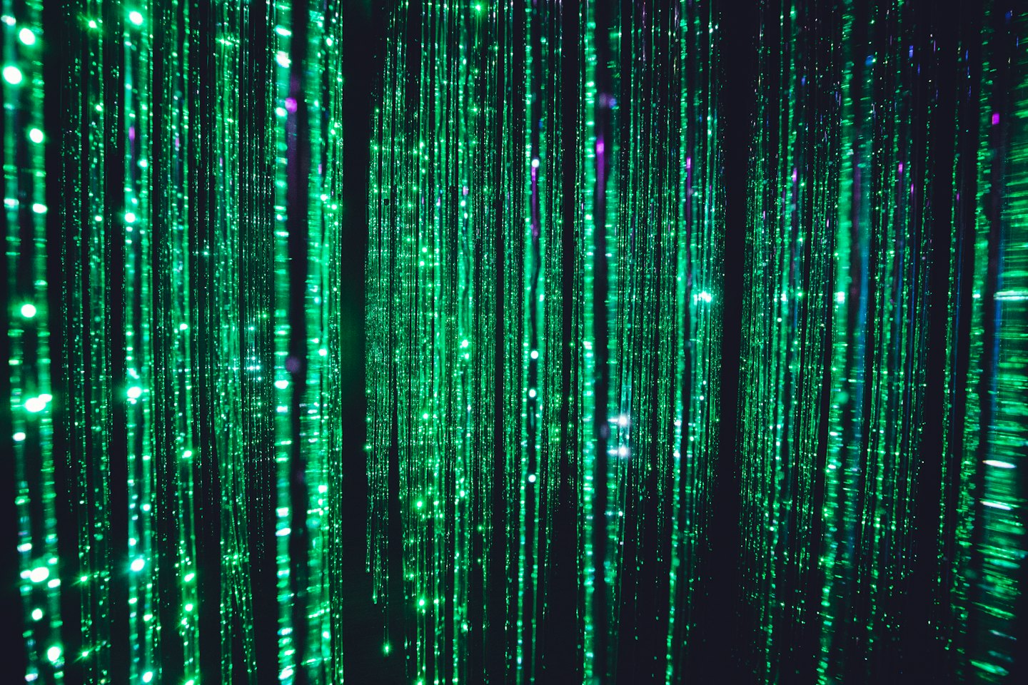 Gloeiende groene lijnen vallen als digitale regen tegen de duisternis.