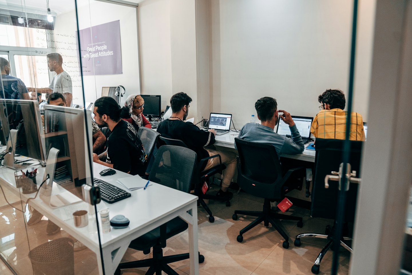 Jonge volwassenen werken samen op laptops in een modern kantoor.
